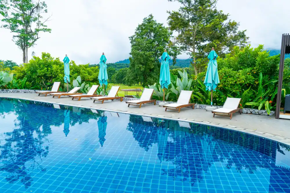 Poolside lounge chairs with closed umbrellas